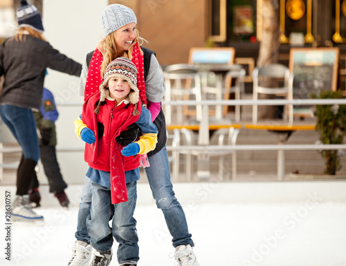 a mother helps her son learn to ice-skate