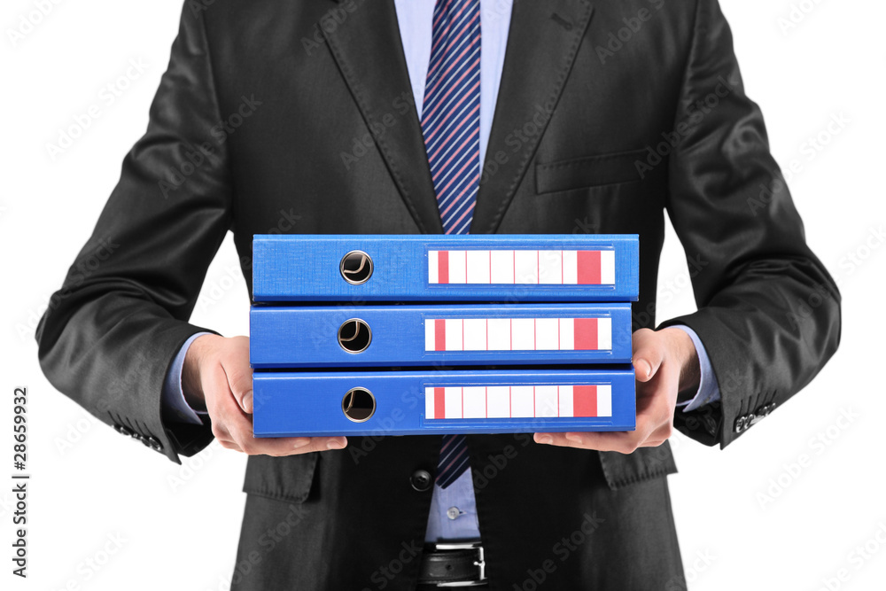 A close up of a businessman holding three blue folders A close up of a businessman holding three blue folders