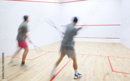 Squash players in action on a squash court (motion blurred image photo