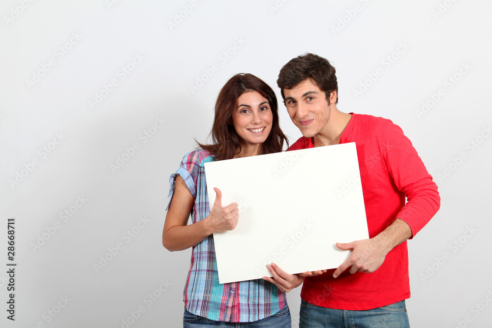 Couple holding whiteboard with happy look Couple holding whiteboard with happy look