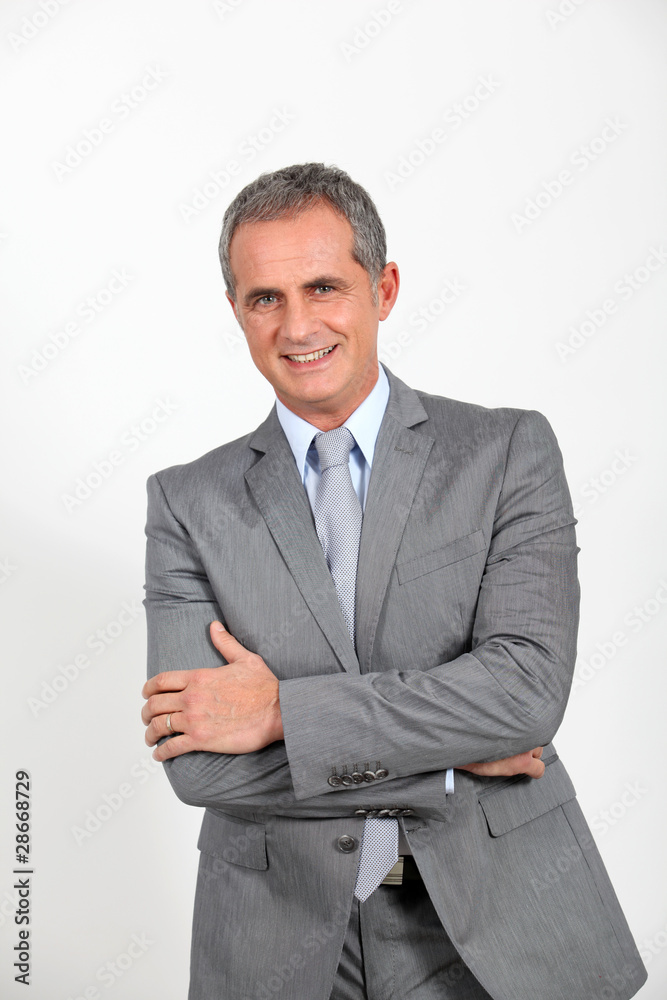 Fototapeta premium Smiling businessman standing on white background