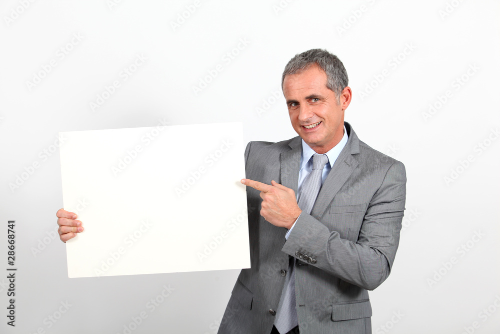 Smiling businessman showing whiteboard Smiling businessman showing whiteboard