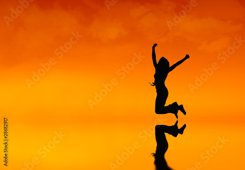 Silhouette of a woman jumping at sunset