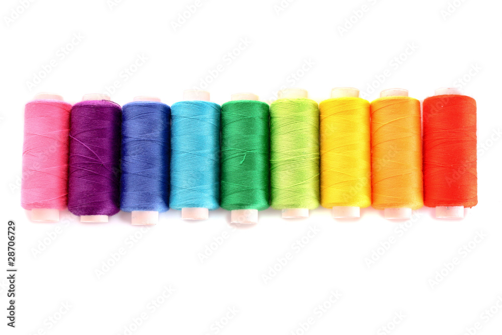 Pile of coloured bobbins of lurex thread isolated on white Pile of coloured bobbins of lurex thread isolated on white