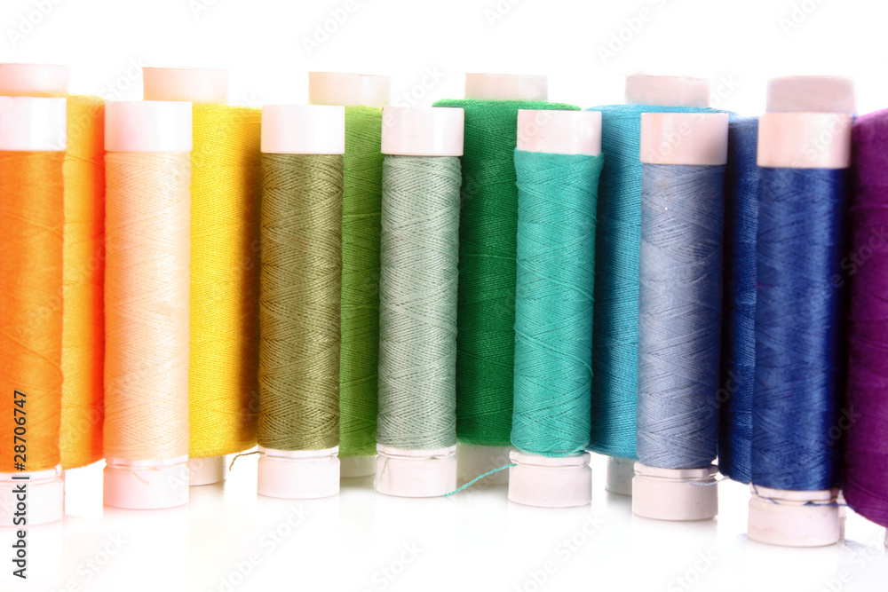Semicircle of many-coloured bobbins of thread isolated on white Semicircle of many-coloured bobbins of thread isolated on white