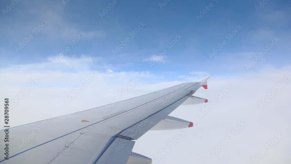 view of wing in sky out from flying airplane