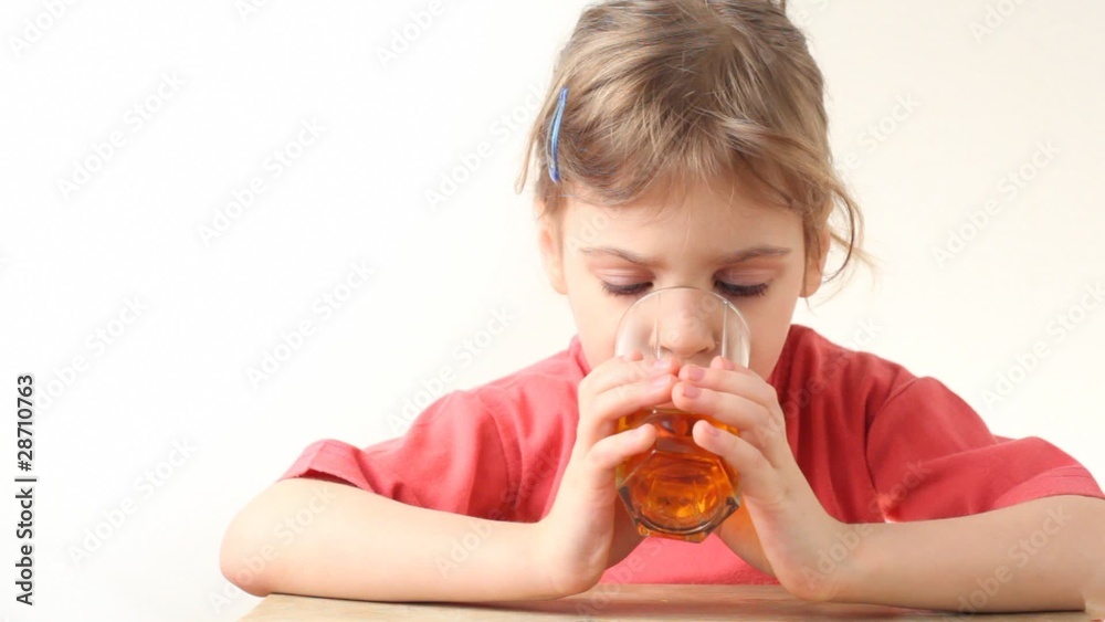little girl drinking orange juice and smiling little girl drinking orange juice and smiling