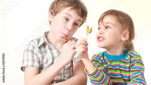 boy and girl licking lollipops in chicken form photo