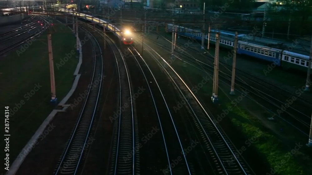 suburban electric train moving on night railway near station suburban electric train moving on night railway near station