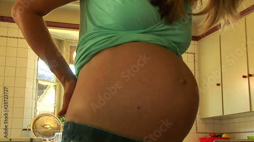 Portrait of pregnant woman showing belly