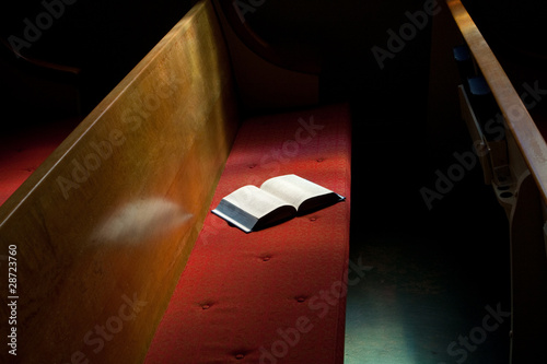 Quadro su tela Open Bible Lying on Church Pew in Narrow Sunlight Band