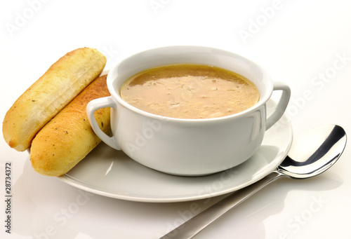French Onion Soup in a white bowl with bread sticks