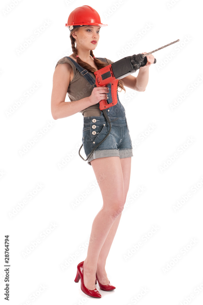 Young playful woman in jeans coverall holding perforator drill Young playful woman in jeans coverall holding perforator drill