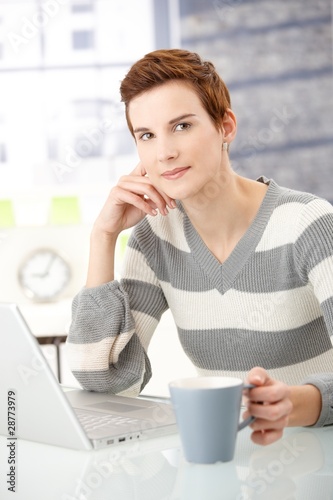 Young woman with coffee mug and laptop