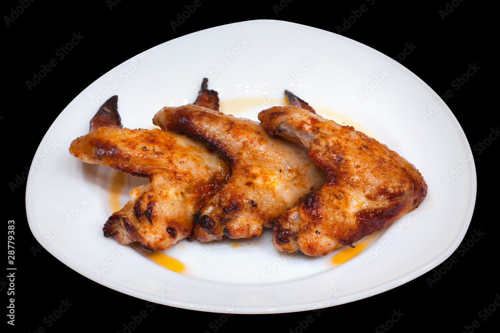 Cooked chicken wings on a plate isolated on black Cooked chicken wings on a plate isolated on black