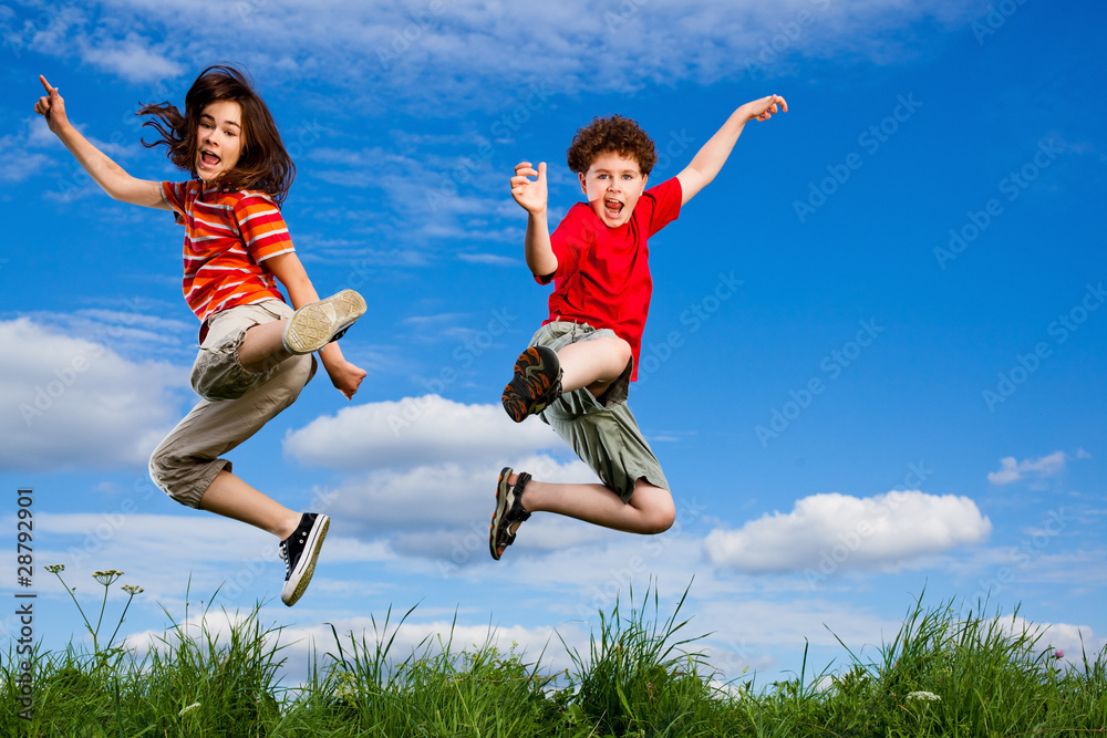 Girl and boy jumping, running against blue sky Girl and boy jumping, running against blue sky