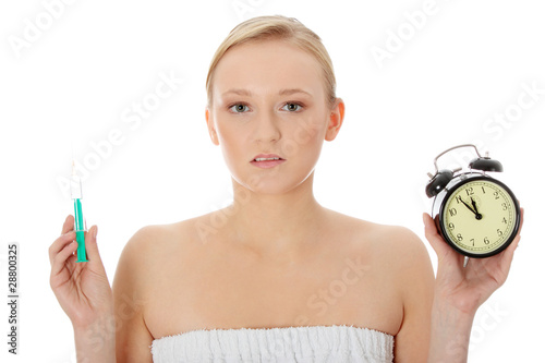 Young woman with syringe and clock photo