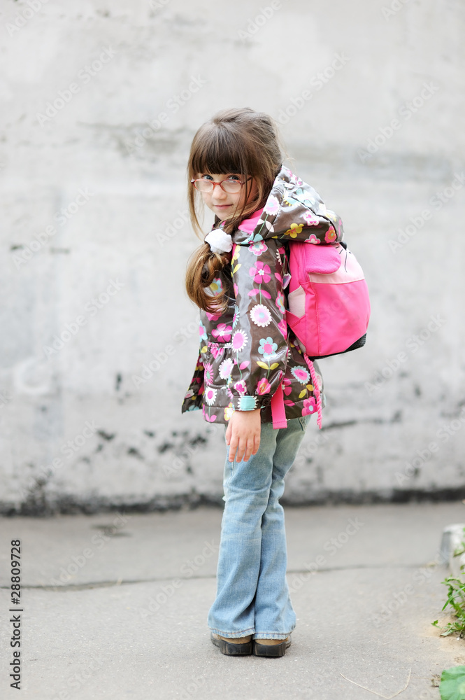 Naklejka premium Adorable preschooler with pink back pack on the way to school