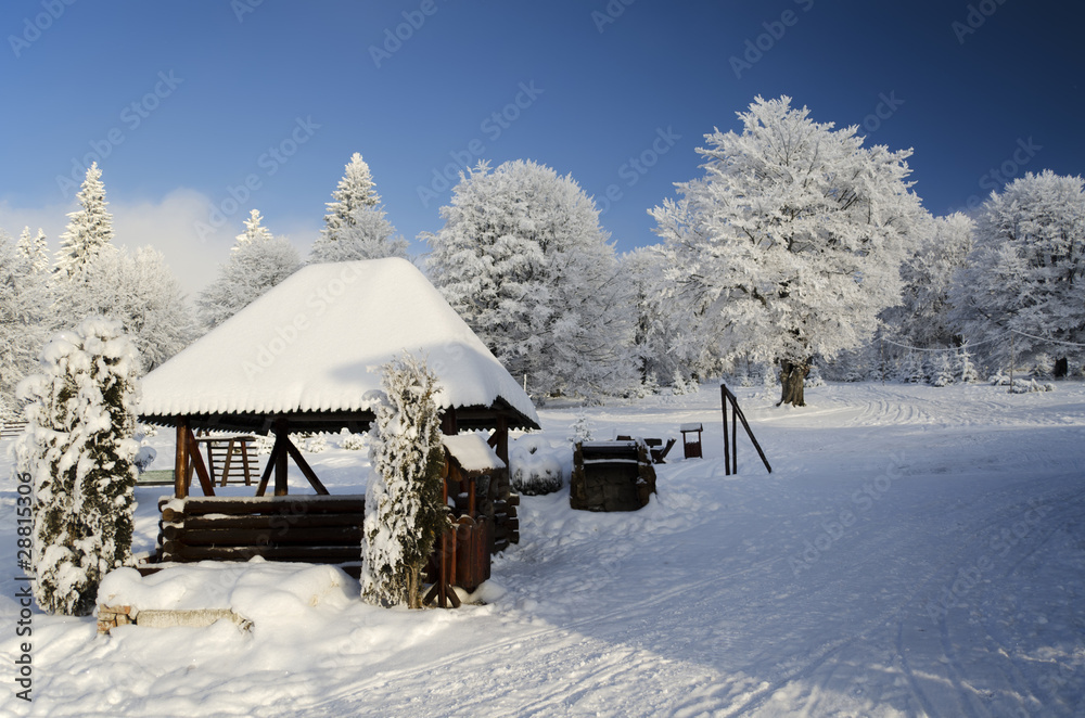 Winter landscape with little wooden house