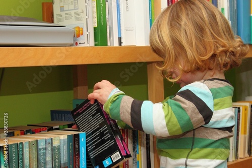 Junge sucht in Bücherregal