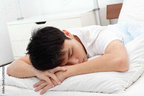 Fotografie A man sleeping on a bed