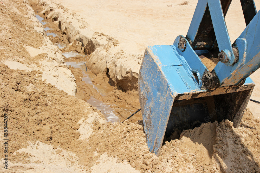 The dredge digs a trench in sand The dredge digs a trench in sand