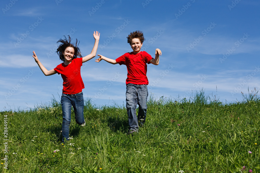 Girl and boy jumping, running against blue sky Girl and boy jumping, running against blue sky