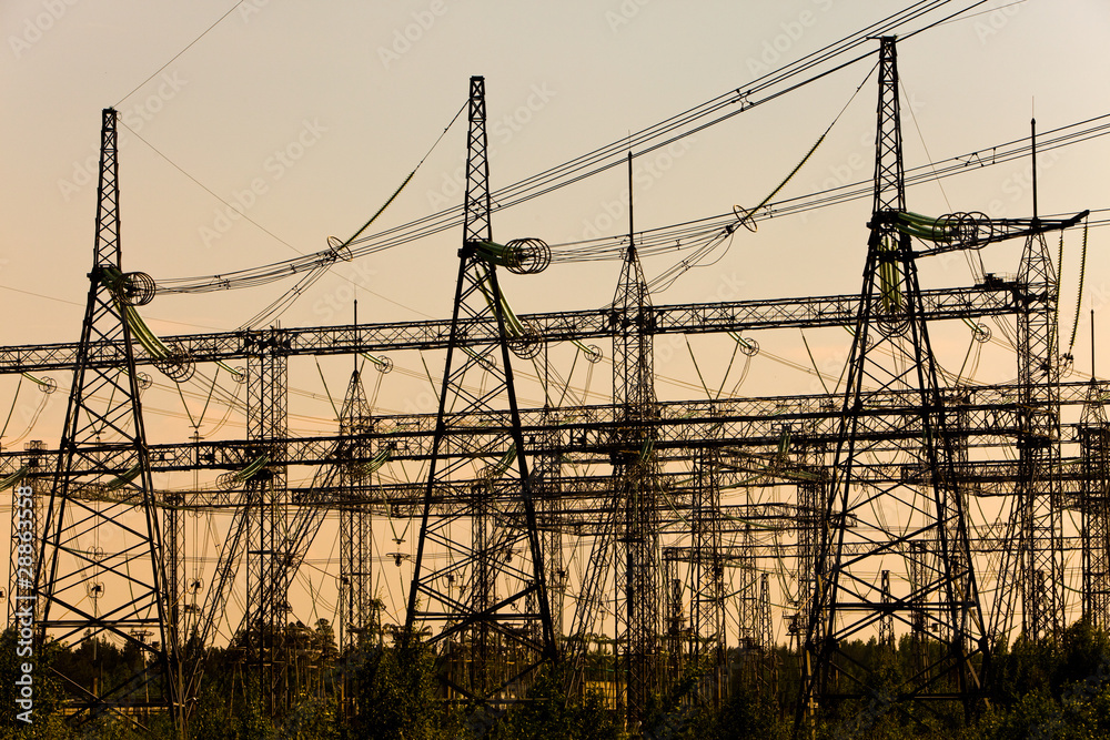 High-voltage line of electricity transmissions on a sunset