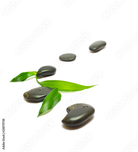 Black stones and bamboo leafs isolated on white