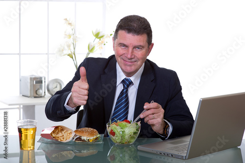 man at office eat green salad healty food