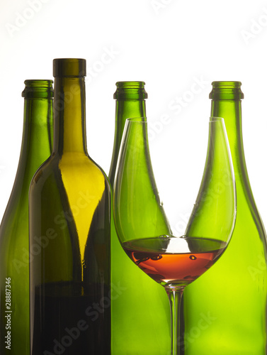 bicchiere di vino rosso con bottiglie