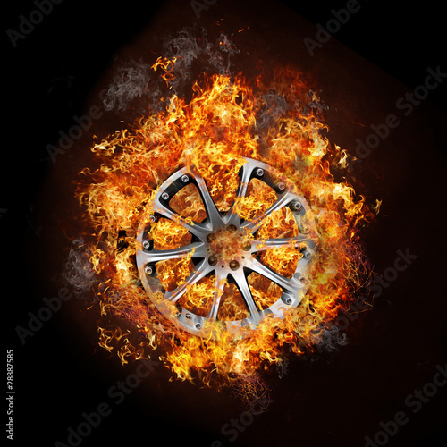 Photo of a car wheel on buring fire with black background