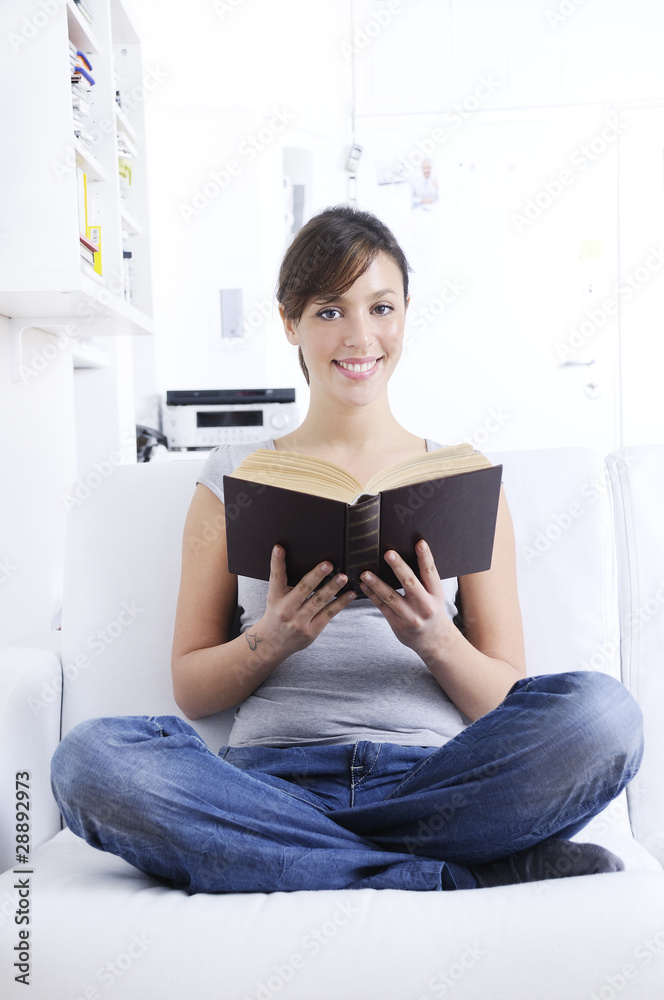 young woman reading book in home interior. young woman reading book in home interior.