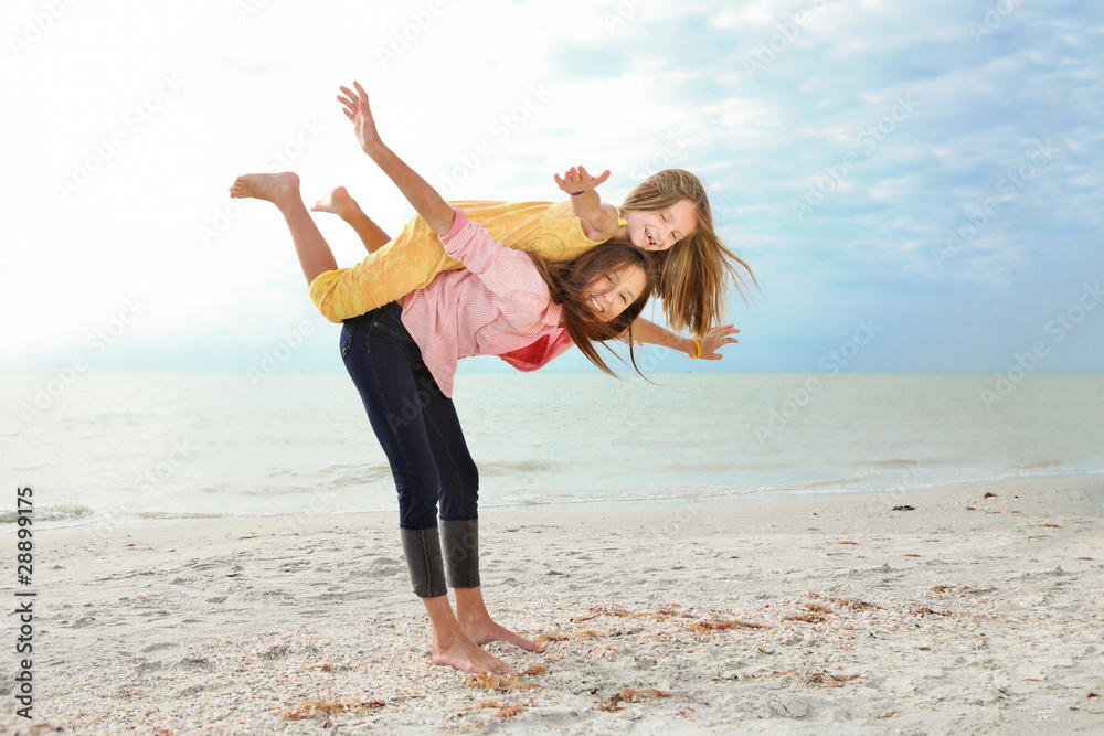 Fototapeta premium Sisters enjoy summer day at the beach.