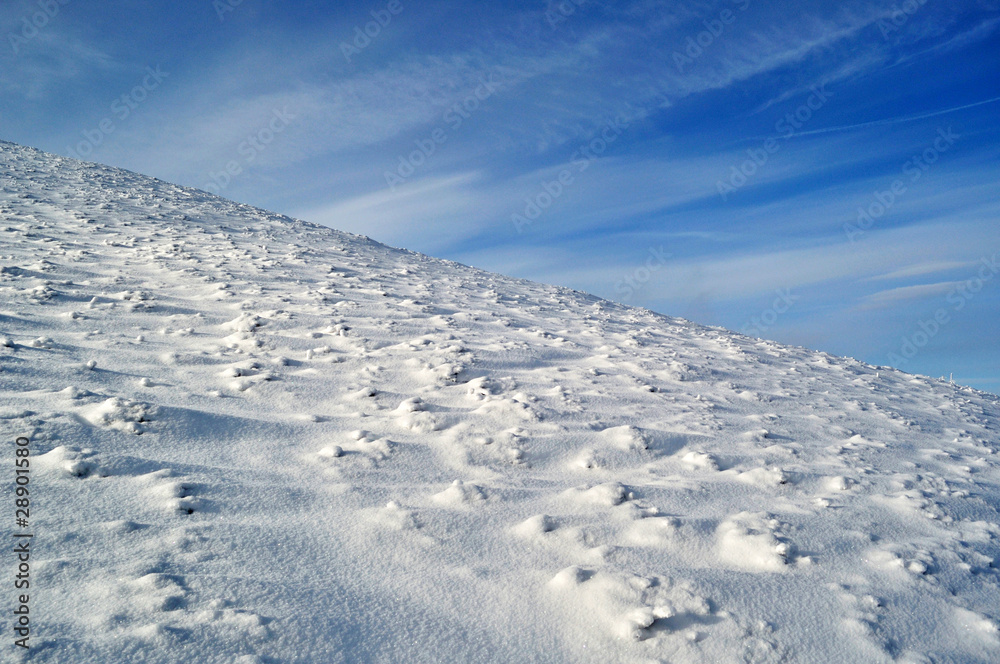 snowy mountain slope and blue sky