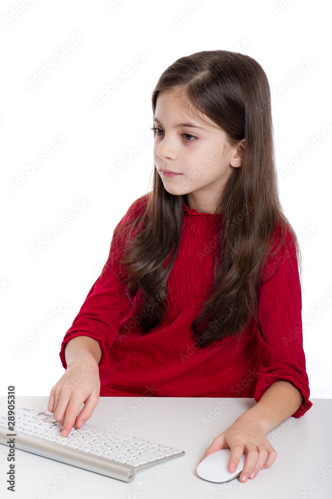 concentrated little girl studying with Pc keyboard and mouse
