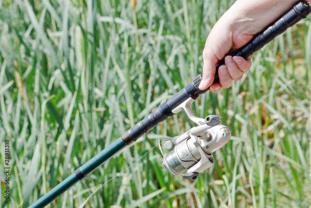Fisherwoman hand holding a fishing rod