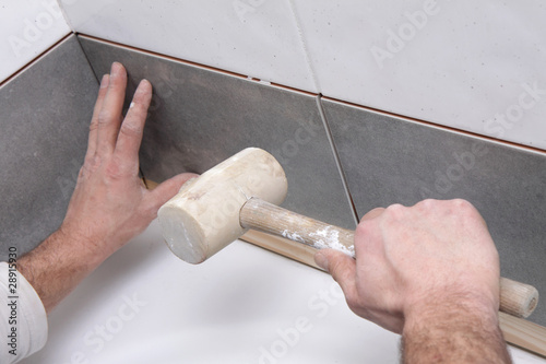 Cuadro en lienzo mains posant carrelage avec maillet