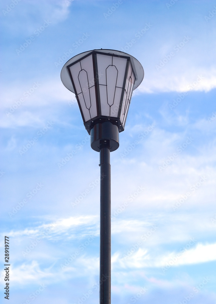 Lantern in front of blue sky with white clouds