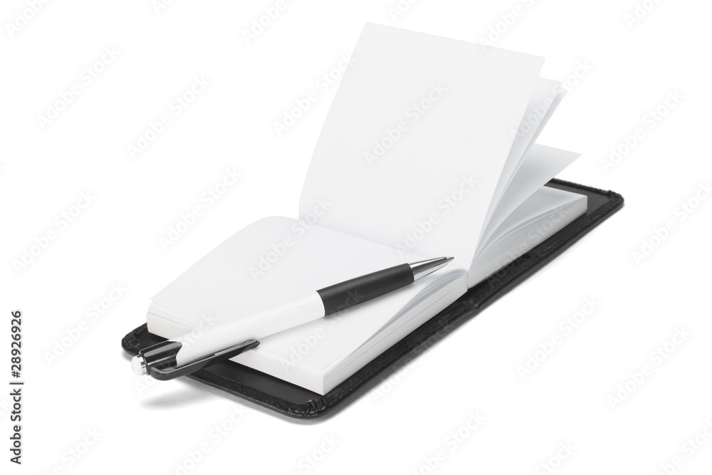 Ballpoint pen on open note pad Ballpoint pen on open note pad