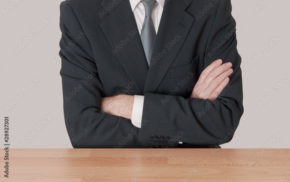 Inaction concept - man at desk with arms crossed Inaction concept - man at desk with arms crossed