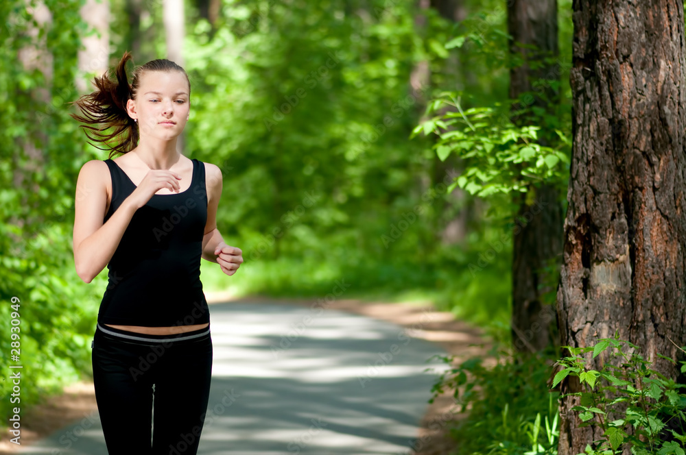 Beautiful woman running in green park