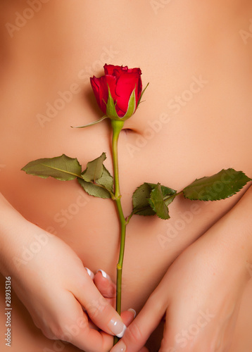 Nude caucasian woman holding red rose