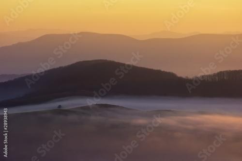 view over hills on a colorful misty morning in autumn
