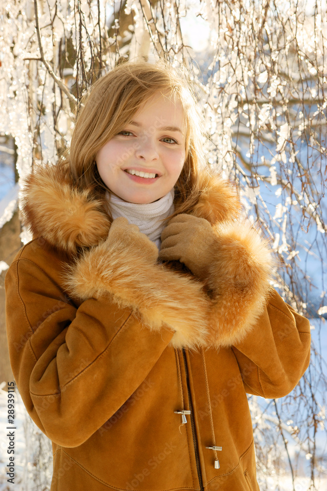 Young blonde woman walking in winter forest