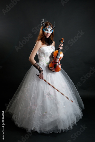 Girl in white dress and mask with violin