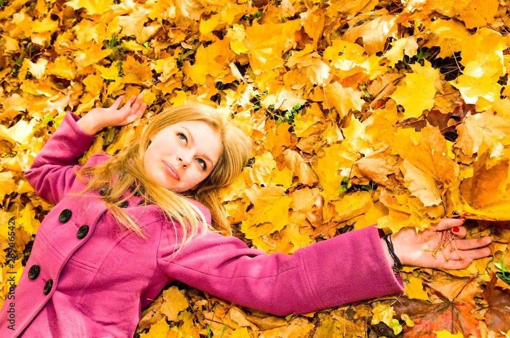 young woman resting on the autumn leaves young woman resting on the autumn leaves