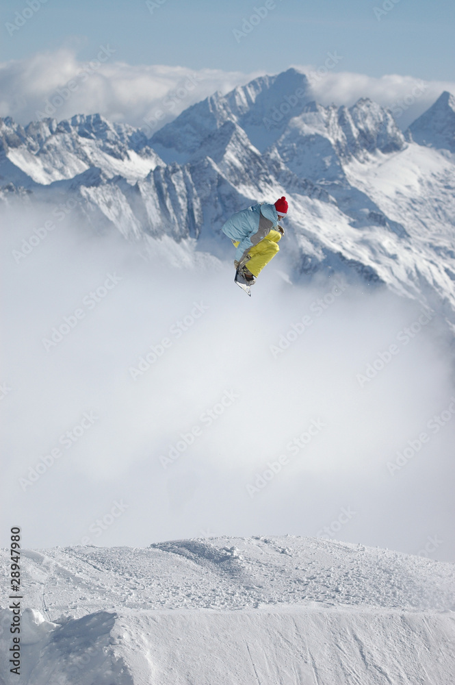 Snowboarder jumping high in the mountains