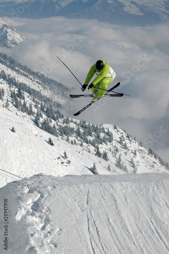 Young freestyle skier jumping high in the mountains