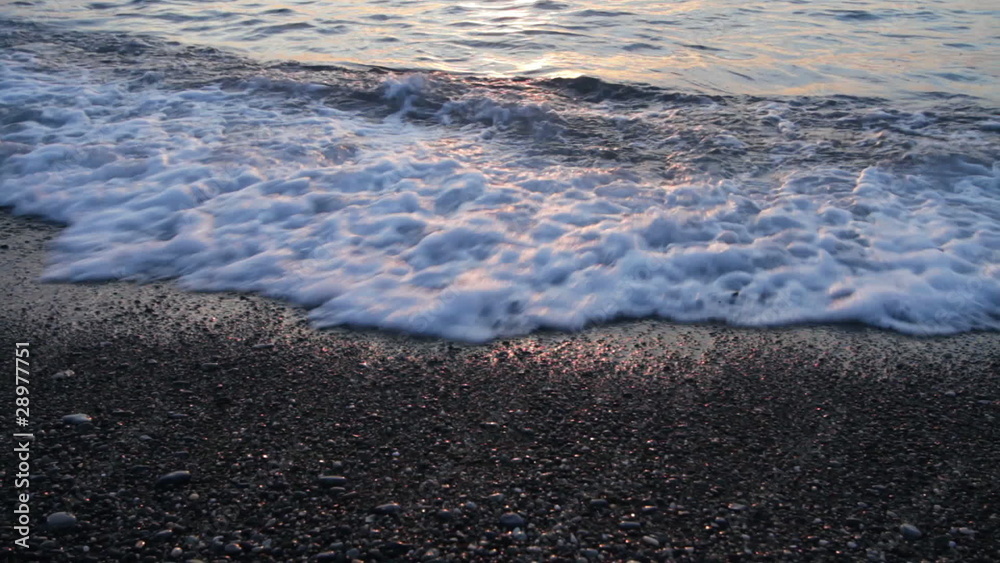 Sunset. Incoming gentle surf on a stone coast. Sunset. Incoming gentle surf on a stone coast.